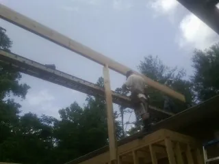 Carpenter setting a ridge beam over a new addition frame — Ice Dam Removal by Roofing Brothers in Zenda