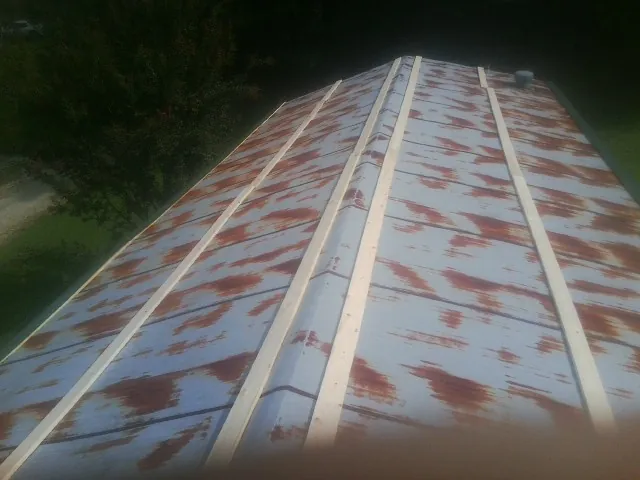 Rusted metal roof panels with new wood purlins before replacement — Storm Damage Roof Repair in Zenda by Roofing Brothers